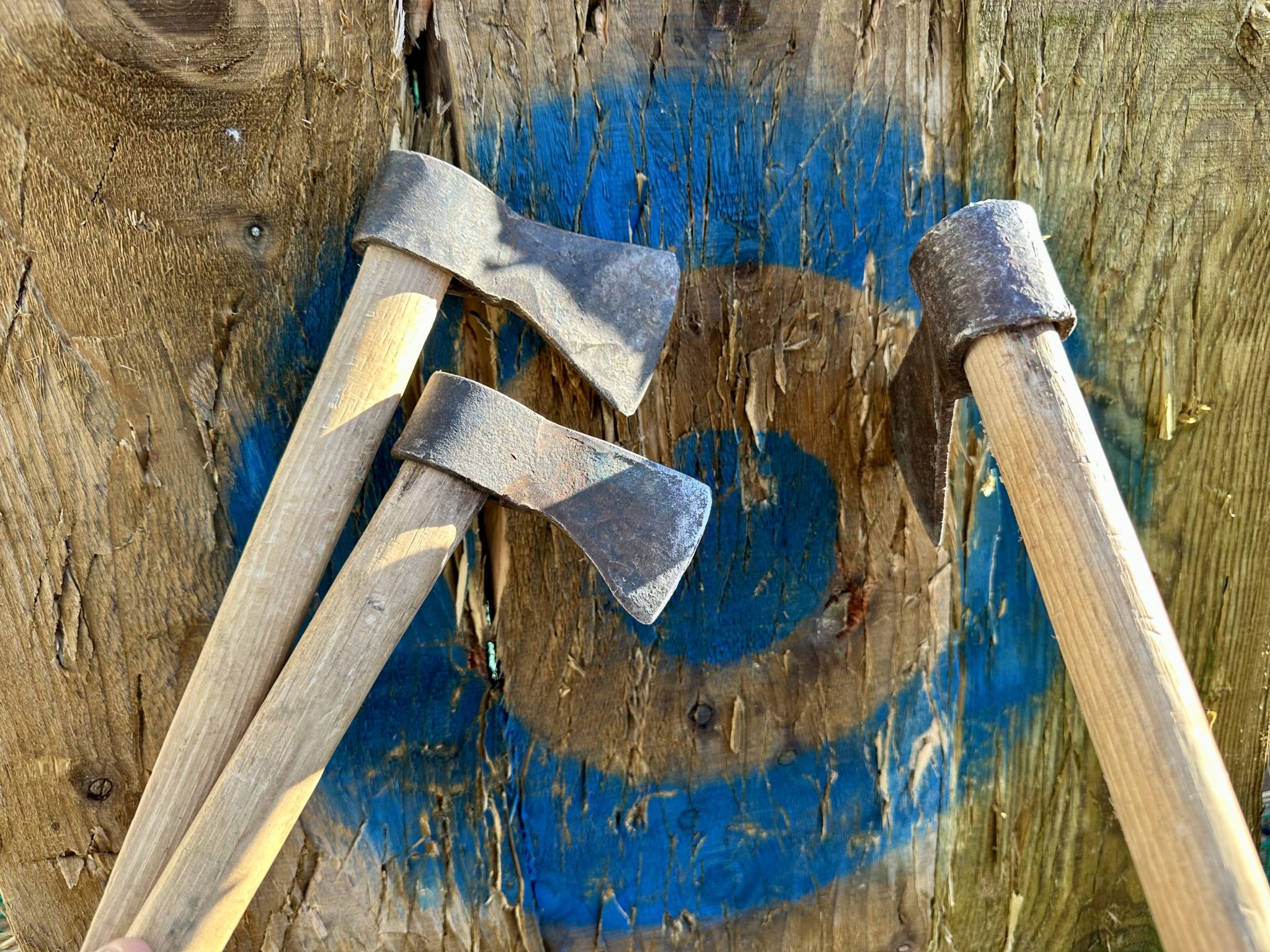 three axes thrown at centre of a wooden target